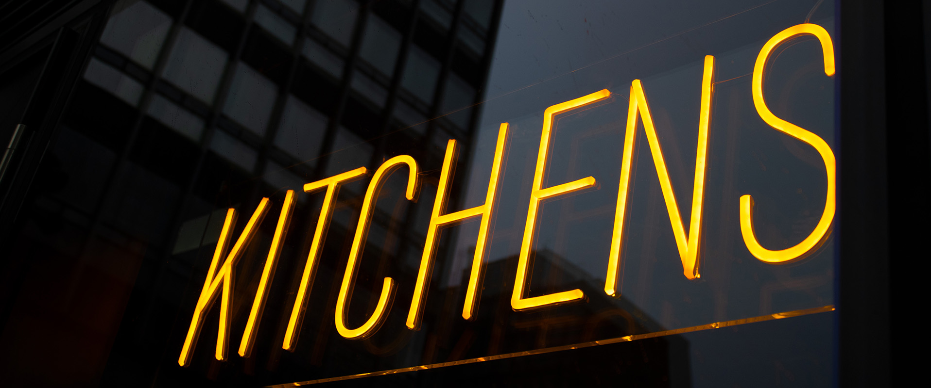 Close up shot of yellow faux LED neon signage with the word "Kitchen"
