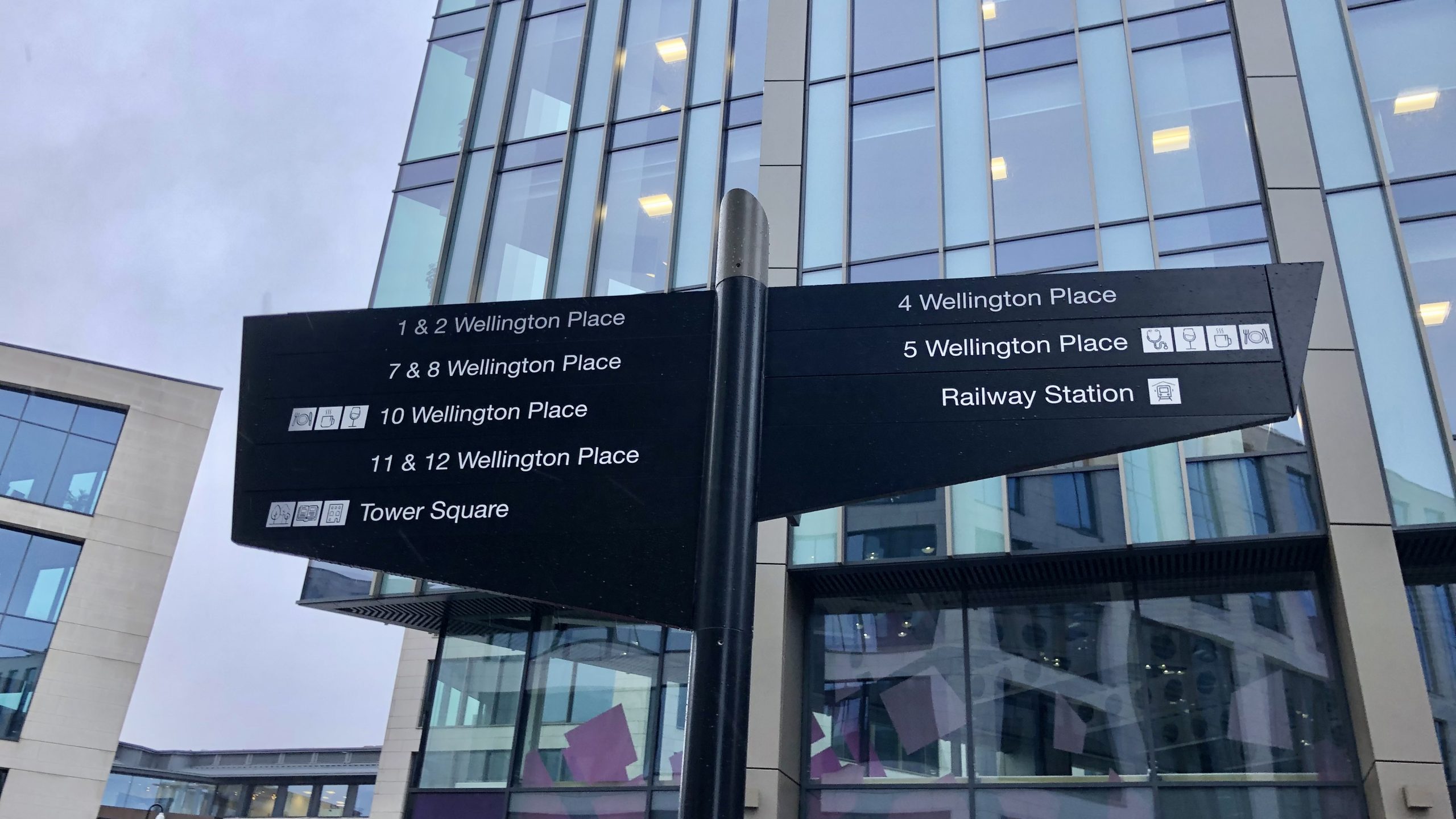 close-up image of outdoor wayfinding fingerpost signage at Wellington Place, Leeds.