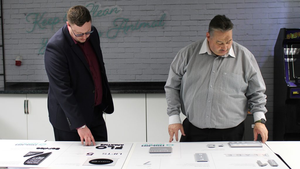Joe (left) and Paul (right), look at a board of samples. 